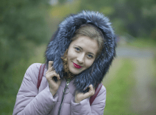 Красивая девушка в меховом капюшоне в лесу